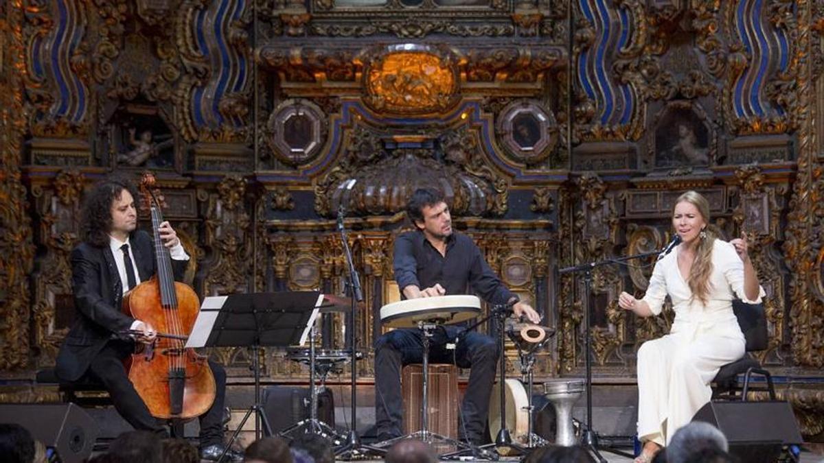 De izquierda a derecha, el violagambista Fahmi Alqhai, Agustín Diassera -sentado sobre un cajón flamenco- y la cantaora Rocío Márquez durante la presentación de 'Diálogos de viejos y nuevos sones', un espectáculo que propone un encuentro entre la música antigua y el flamenco, en la Bienal de Flamenco de Sevilla de 2016.