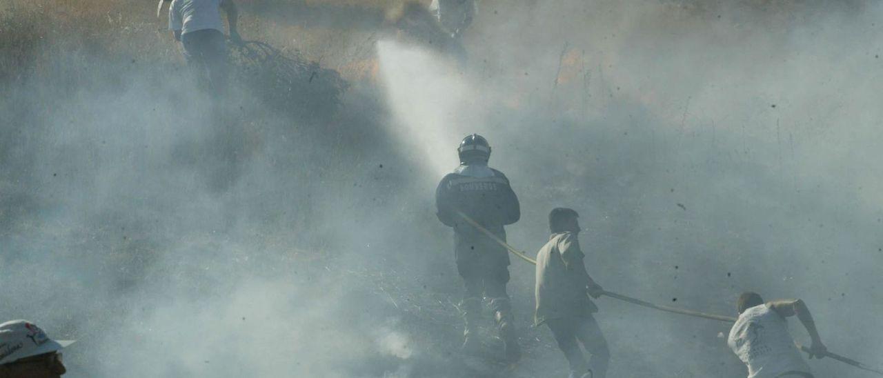 Vecinos ayudando a los bomberos en la extinción de un incendio en Bretó hace algunos años.