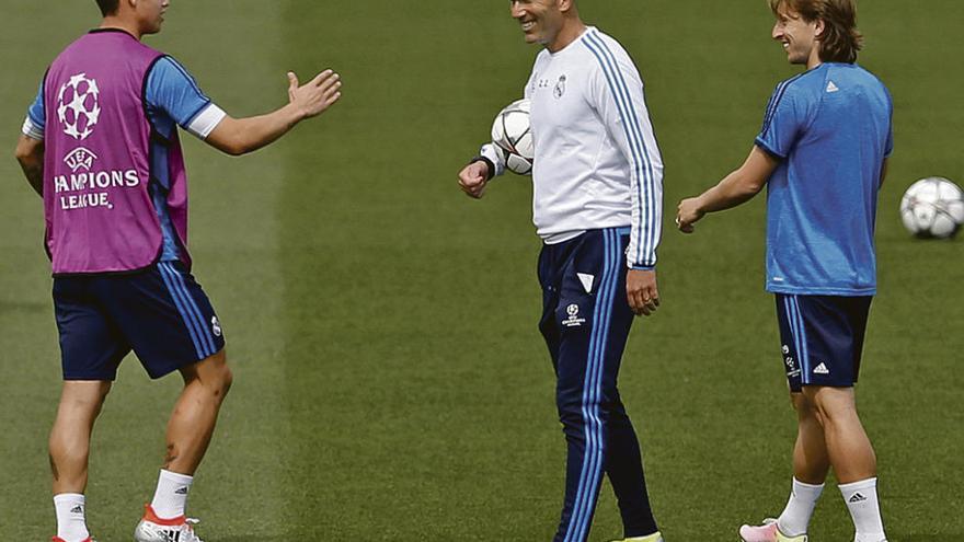 Zidane, sonriente, entre James, a la izquierda, y Modric.