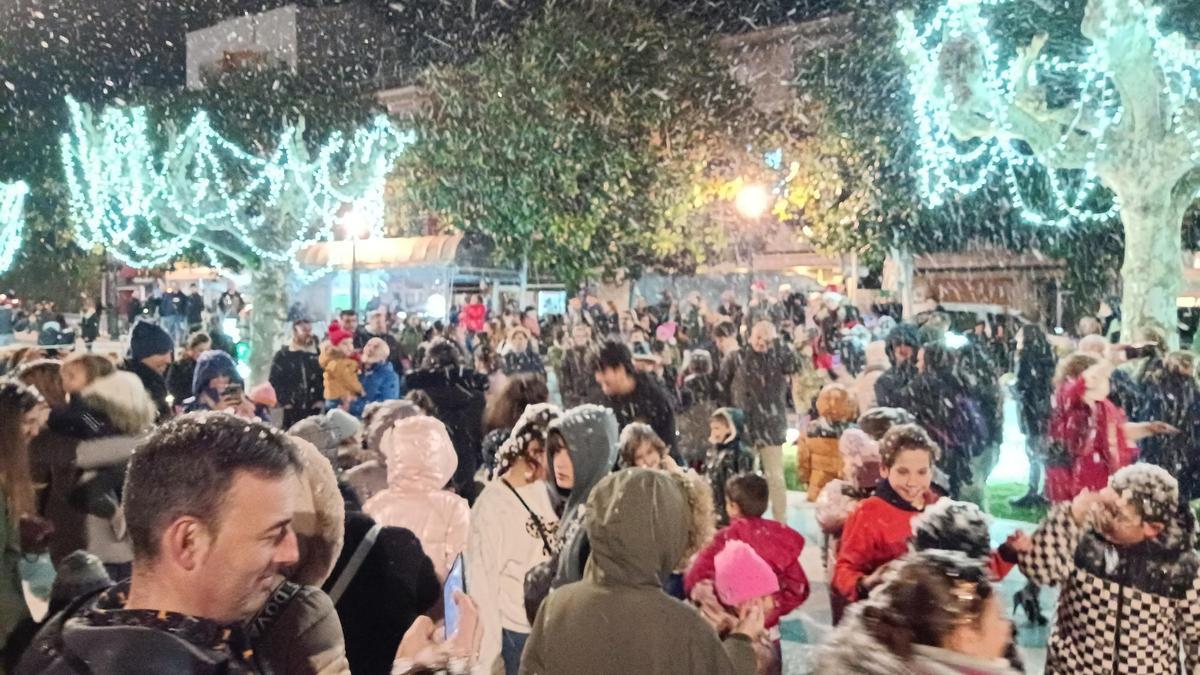 Los asistentes a la fiesta disfrutan de la nieve artificial, esta tarde, en la alameda de Chapela