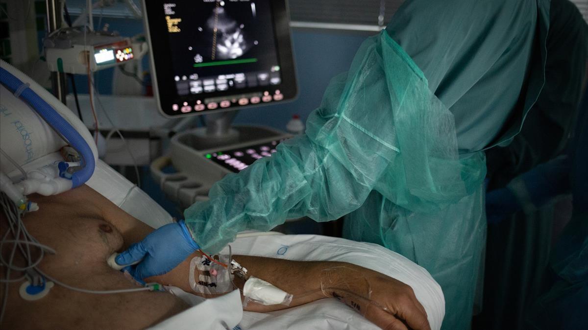 06 11 2020 Personal sanitario visita a un enfermo ingresado en la Unidad de Cuidados Intensivos -UCI- del Hospital de la Santa Creu i Sant Pau  integrado en la Red Hospitalaria de Utilizacion Publica de Catalunya  en Barcelona  Catalunya (Espana)  a 6 de noviembre de 2020  Ahora que la region pasa por la segunda ola de la pandemia  la Conselleria de Sanidad de Catalunya confirma que a dia de hoy la red de unidades de cuidados intensivos (UCI) del sistema esta al 87  de su capacidad y Catalunya ha registrado 290 244 casos confirmados acumulados de coronavirus   SALUD   David Zorrakino - Europa Press