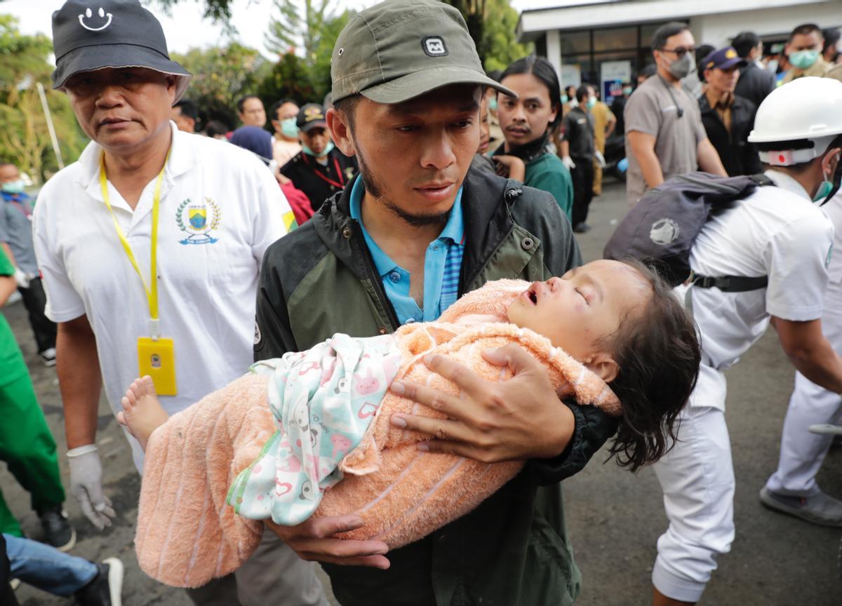 Cianjur (Indonesia), 21/11/2022.- Rescuers carries the body of a girl, victim of the earthquake that hit Cianjur, Indonesia, 21 November 2022. An earthquake with a 5.6 magnitude that hit the southwest of Cianjur District, West Java Province killed at least 20 people and hundreds were injured. (Terremoto/sismo) EFE/EPA/ADI WEDA