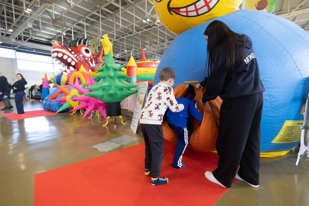 Una monitora guía a dos niños en una de las atracciones habilitadas para la feria.
