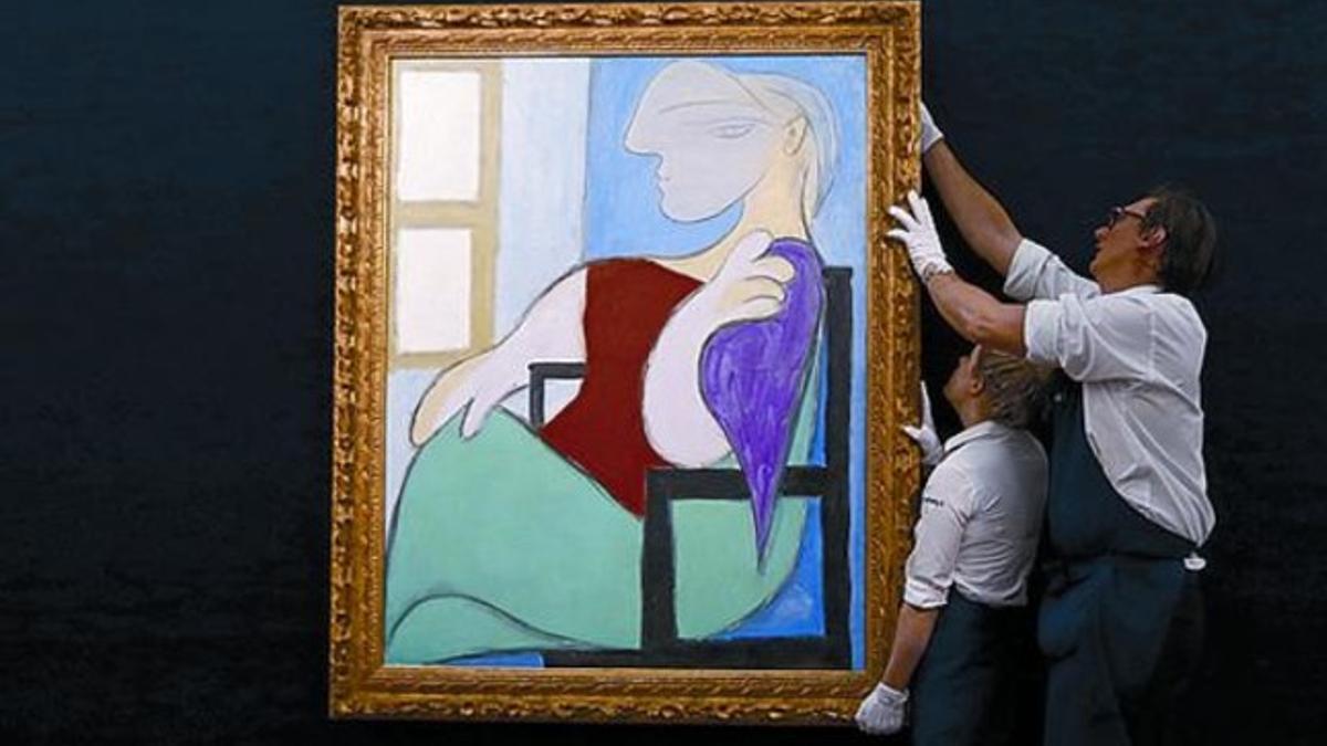 Dos trabajadores de Sotheby's sujetan el óleo subastado de Picasso.