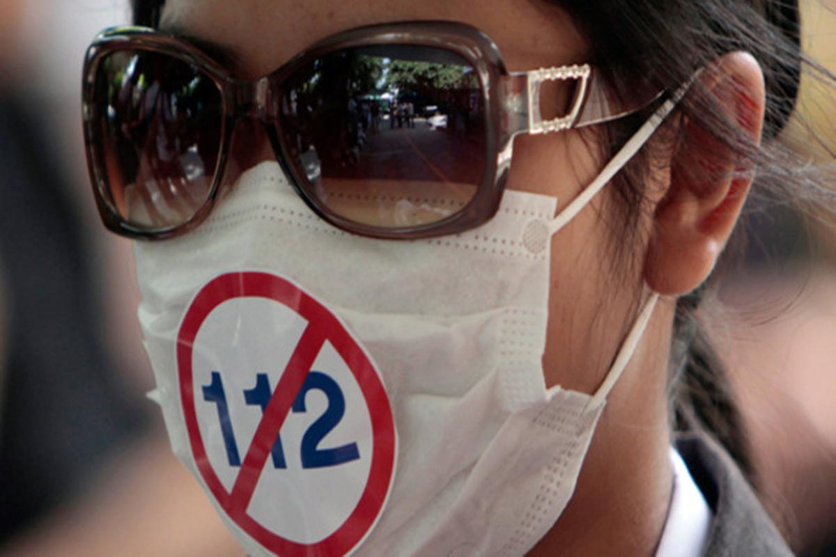 Un protestant emmascarat es manifesta en contra del codi 112 del codi penal Tailandès --que prohibeix criticar la monarquia-- a Bangkok(Tailàndia).