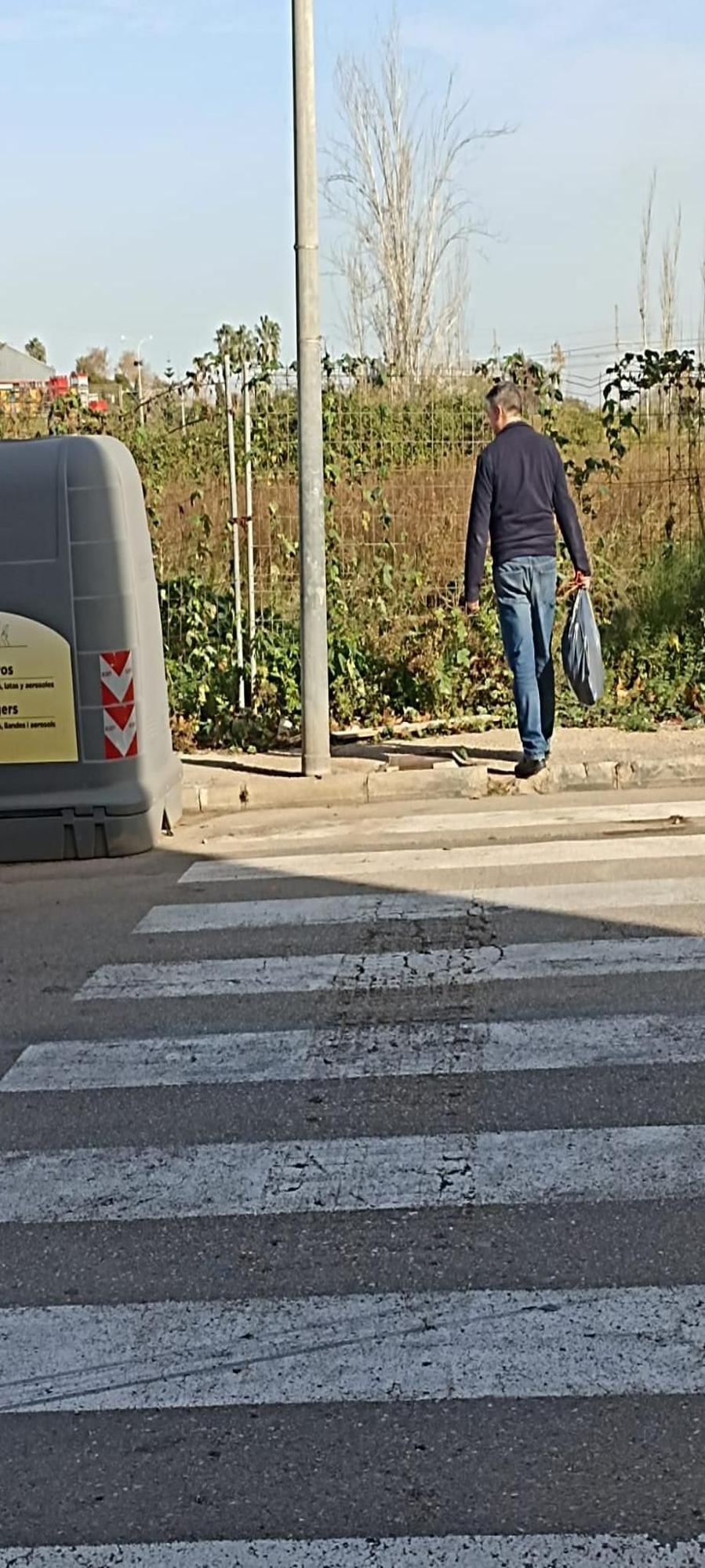 Un vecino cruza el paso de peatones que genera las quejas para tirar la basura en la isla de contenedores.