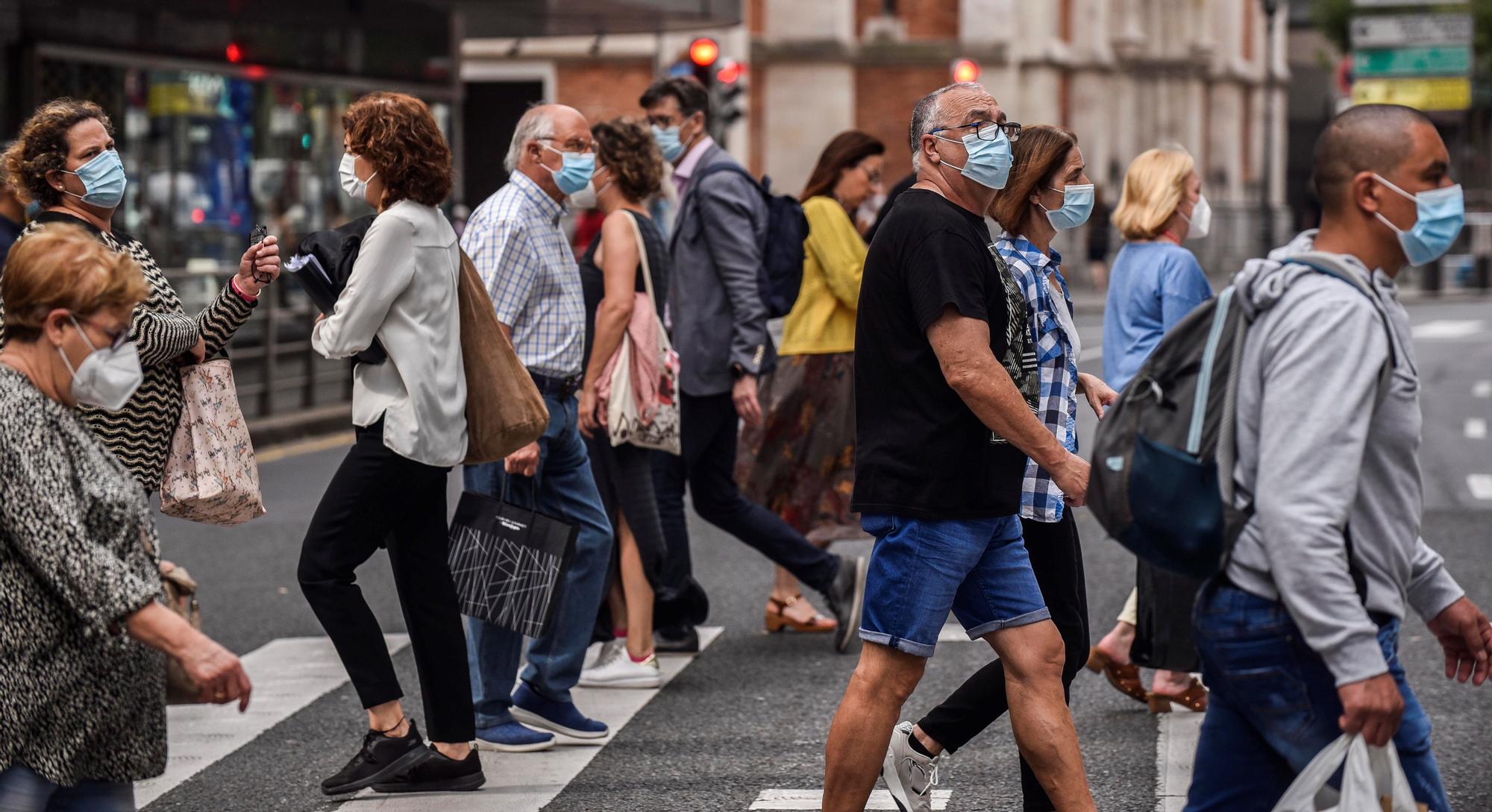 Un grupo de ciudadanos camina por las calles de Bilbao protegidos con mascarillas.