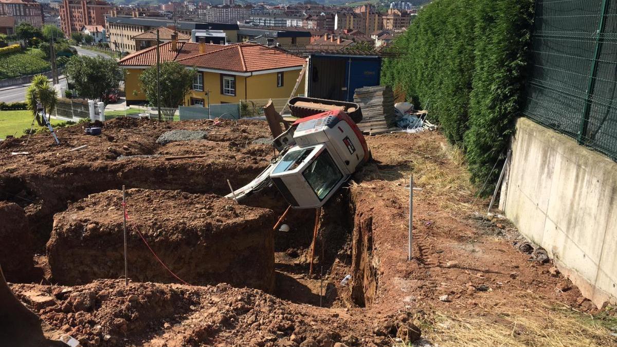 La pala retroexcavadora, volcada en el solar en obras.