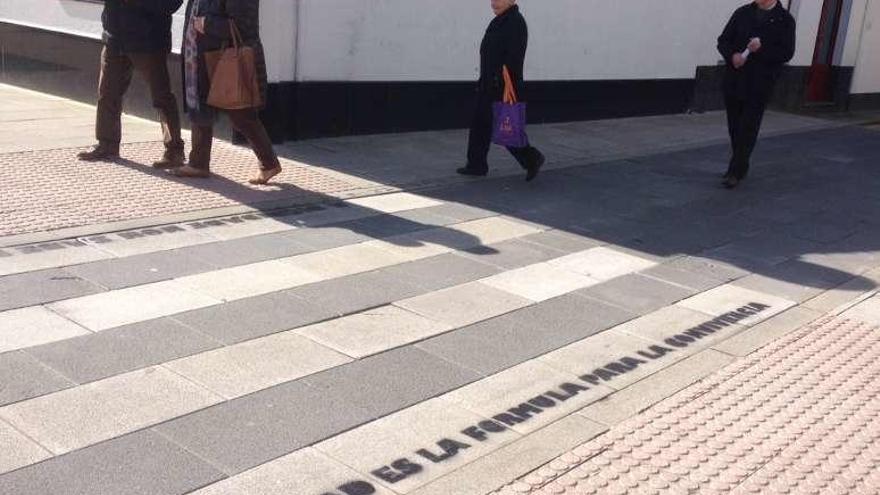 Viandantes leen algunas de las frases pintadas en los pasos peatonales.