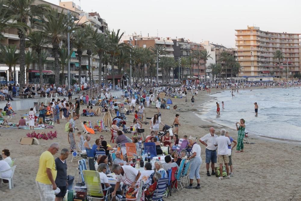 Noche de hogueras, baños, en las playas de la Vega Baja. En las imágenes grupos de amigos y familias en la playa del Cura de Torrevieja