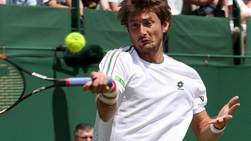 El tenista español Juan Carlos Ferrero devuelve la bola al estadounidense Sam Querrey durante el partido que les han enfrentado en la primera ronda del torneo de Wimbledon que se celebra en el club All England Lawn de Londres, Reino Unido, hoy lunes 23 de junio.