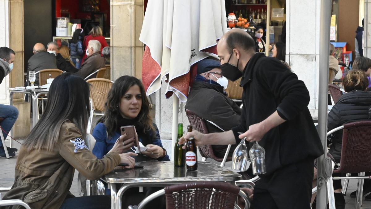 La progresiva vuelta a la actividad en la hostelería impulsa la recuperación del empleo en la provincia de Castellón. Imagen de un camarero trabajando en una terraza de la plaza Santa Clara en Castelló.