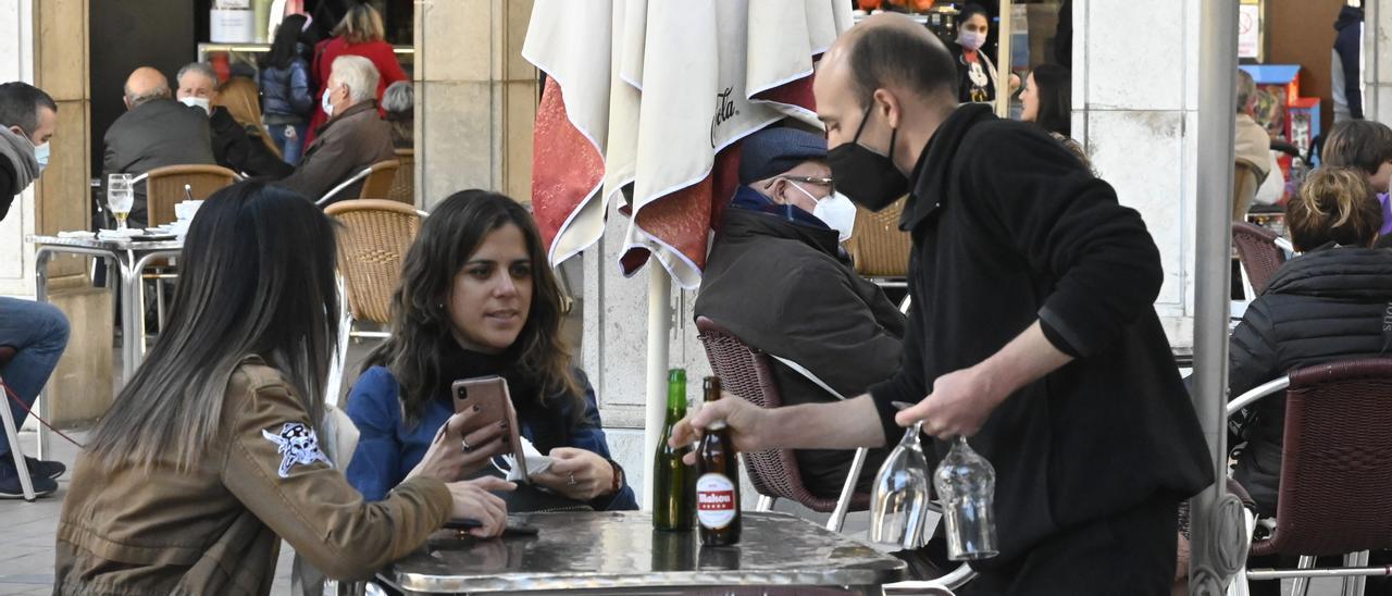 La progresiva vuelta a la actividad en la hostelería impulsa la recuperación del empleo en la provincia de Castellón. Imagen de un camarero trabajando en una terraza de la plaza Santa Clara en Castelló.