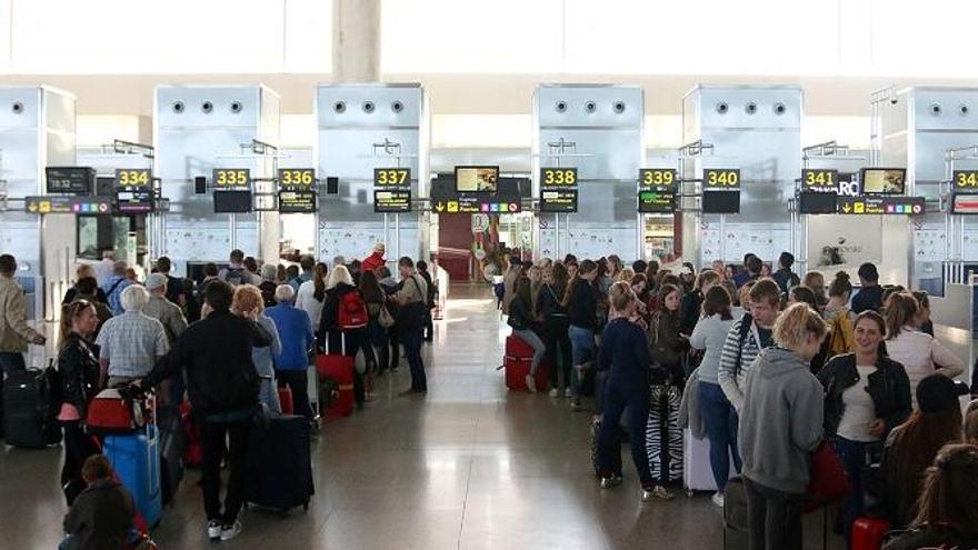 La imagen muestra a viajeros haciendo cola en el check-in del Aeropuerto de Málaga.