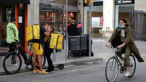 ’Riders’ de Glovo hacen tiempo en espera de que salgan pedidos para repartir.