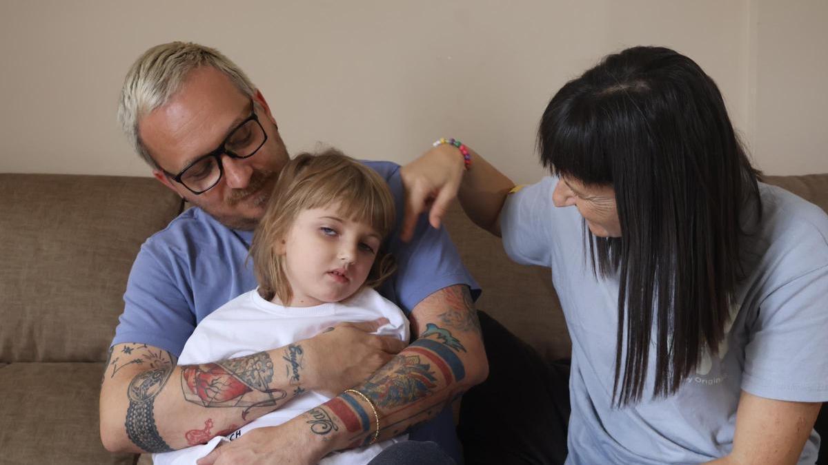 Lara, en los brazos de su padre, Roberto, mientras su madre, María Teresa, le acaricia el pelo.