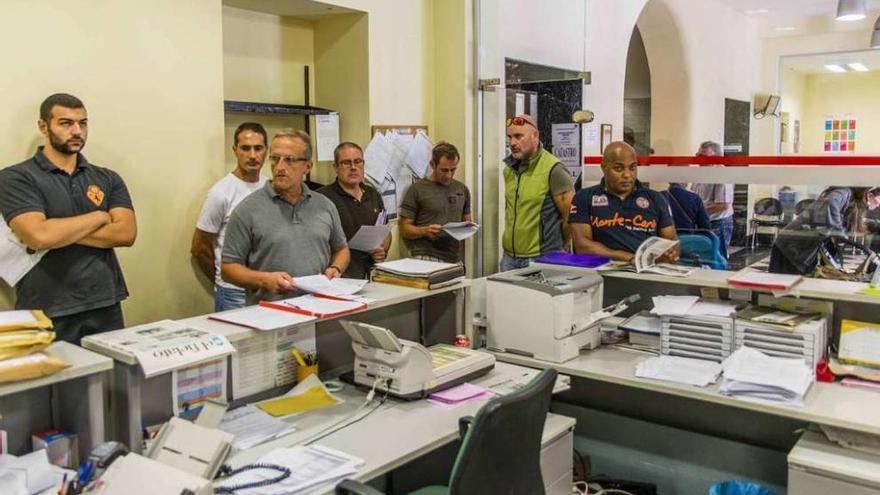 Cinco agentes de la Policía Local vestidos de paisano (en el centro de la imagen), presentando ayer varios escritos en el Registro del Ayuntamiento de Llanes.