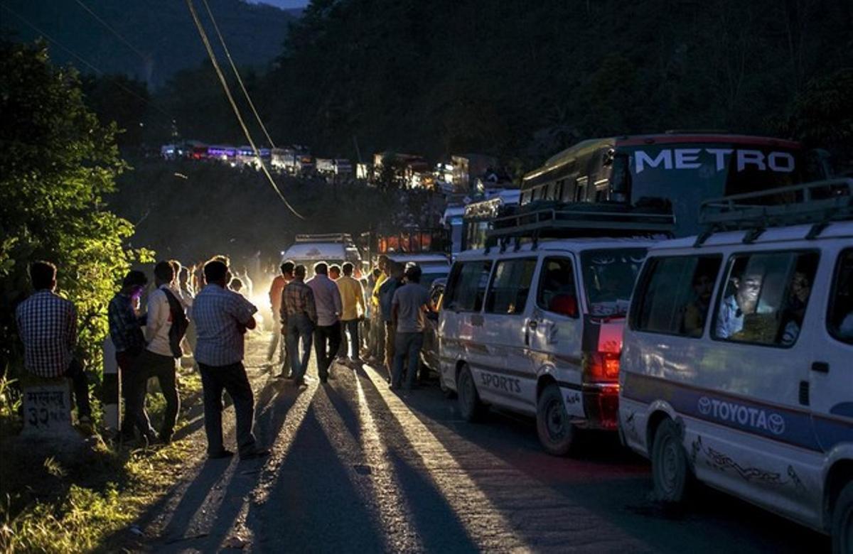 Largas colas de personas con vehículos se desplazan a lugar seguro camino a pesar de los deslizamientos de tierras causados por el terremot en Kurintar , Nepal