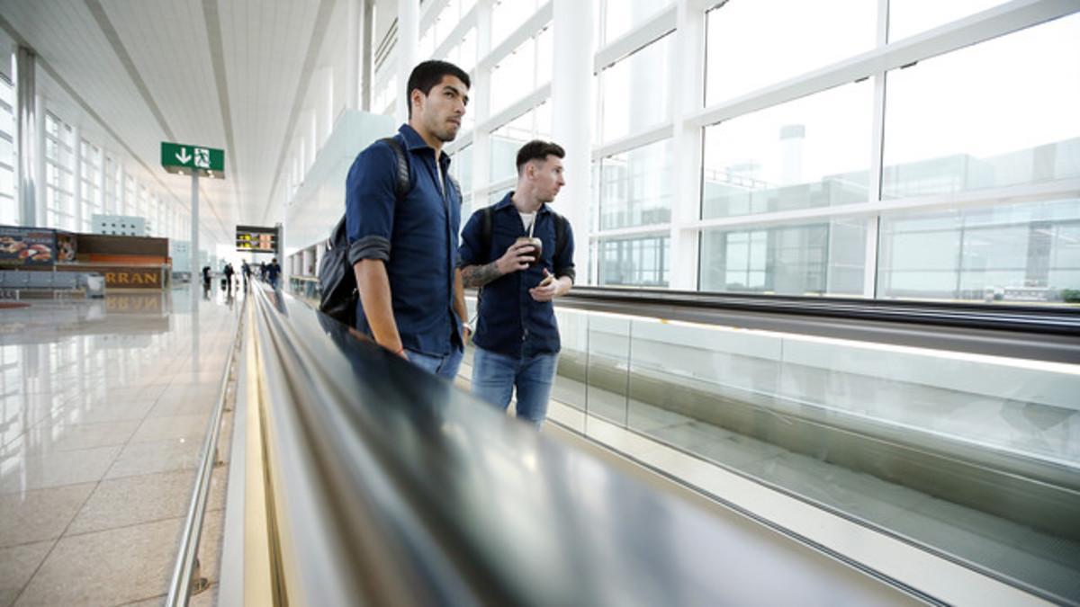 Luis Suárez y Leo Messi, en el aeropuerto de El Prat, camino de Granada.