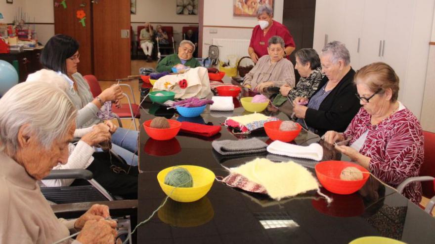 El grupo de mujeres que residen en el Centro Asistencial  de Mombuey durante el taller de tejedoras solidarias de la asociación La IAIA con el que confeccionan piezas artesanas. | Araceli Saavedra