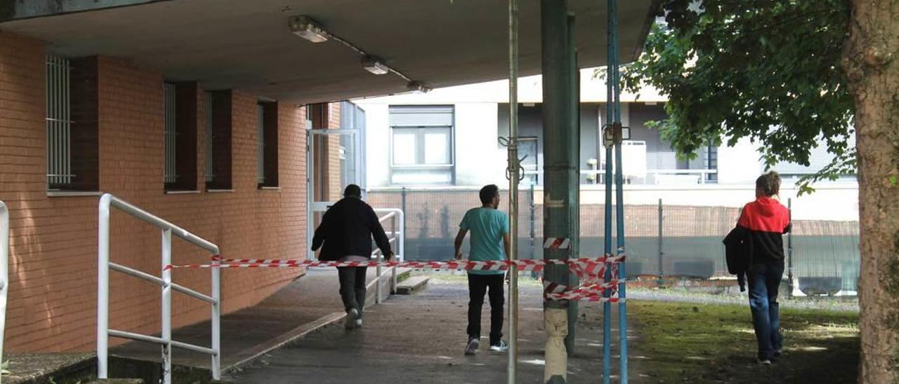 Pacientes de la Unidad de Toxicomanía pasando ayer bajo el porche apuntalado.