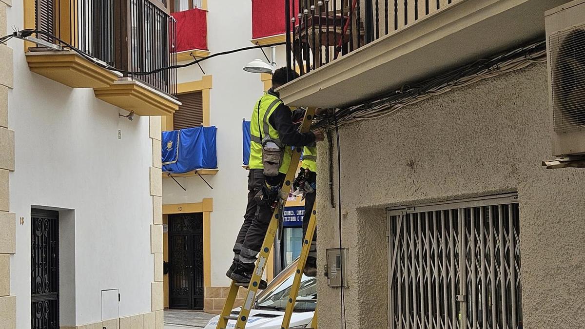 Operarios instalando cableado hace unos días en la calle Álamo, una de las principales vías del casco histórico.