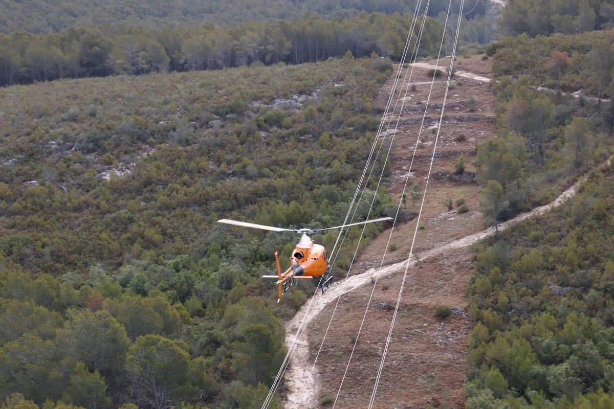 L'helicòpter d'Endesa sobrevolant la línia elèctrica en la campanya contra incendis