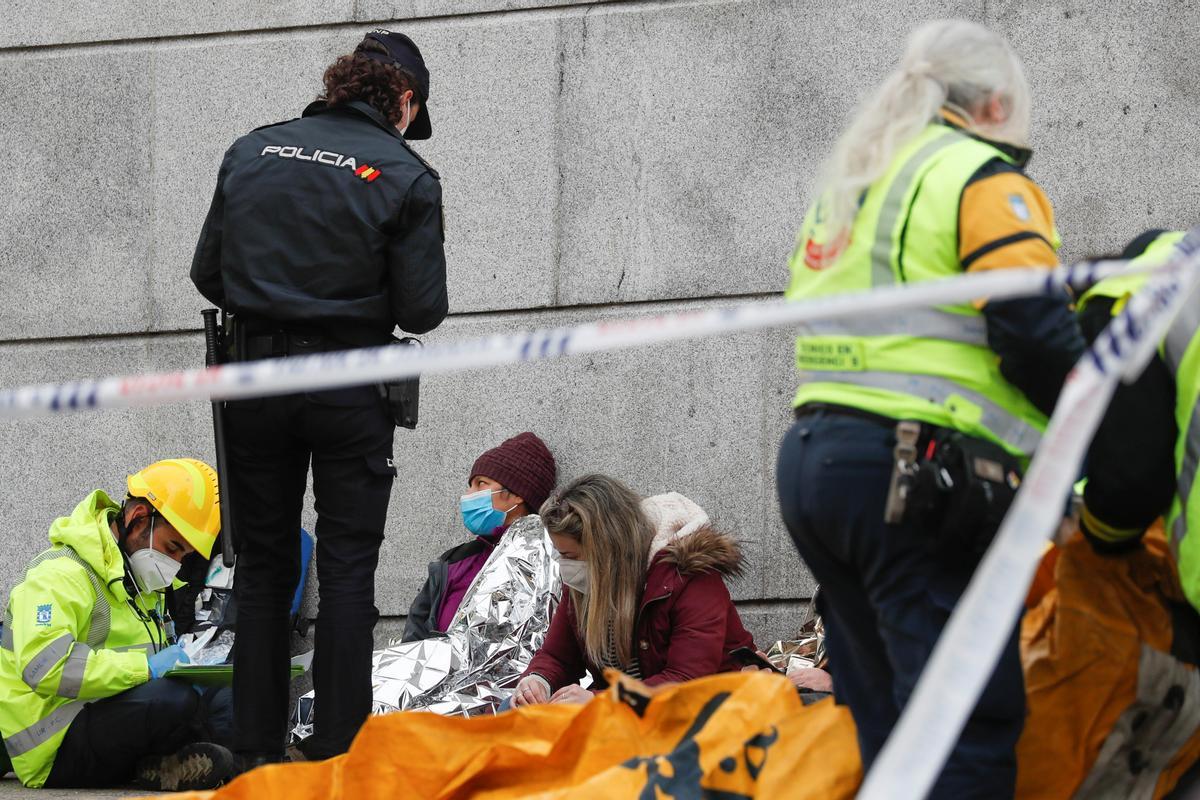 La policía y efectivos de emergencias atienden a las personas afectadas por la explosión del edificio de Madrid