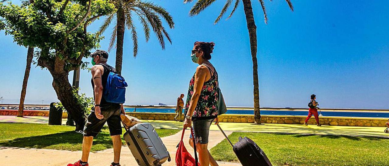 Una pareja de turistas cargan con sus maletas en Benidorm.