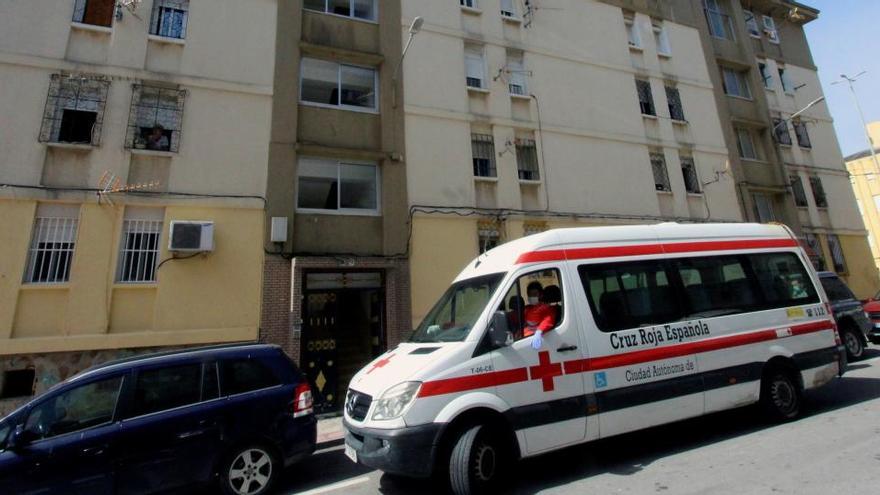 Un vehículo de la Cruz Roja estaciona frente a un bloque de viviendas en Ceuta.