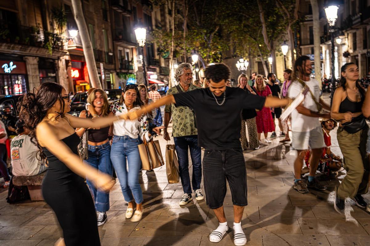 Una pareja bailando en el paseo del Born, en Barcelona.
