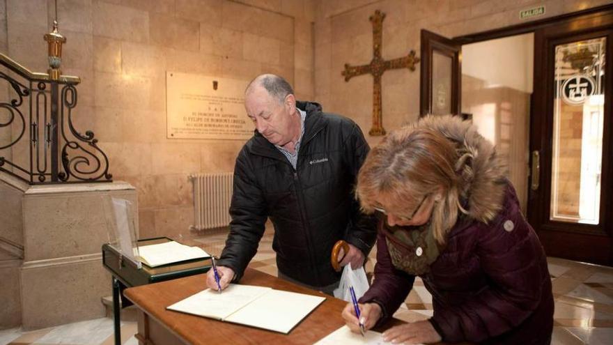 José Gonzalo Suárez y María Josefa Curiel, ayer al mediodía, firmando en los libros de condolencias en el vestíbulo del Ayuntamiento.