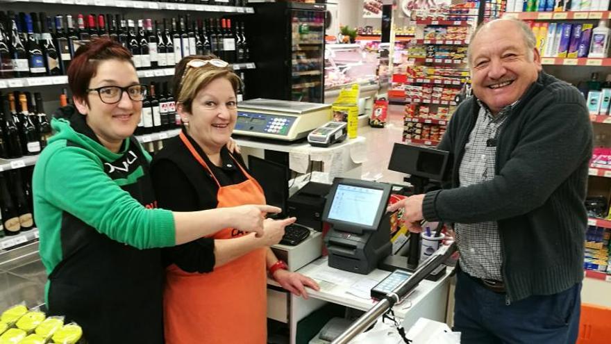 Els responsables del supermercat Suma, Ramon Gangonells, Maria Dolors Lleixà i la filla, Cristina Gangonells, davant el terminal electrònic