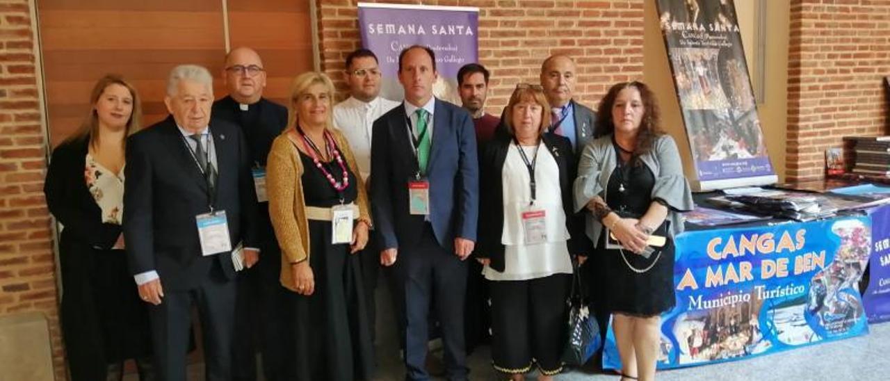 Los delegados de las cofradías, en el encuentro de León con un cartel turístico de Cangas.   | G.N.