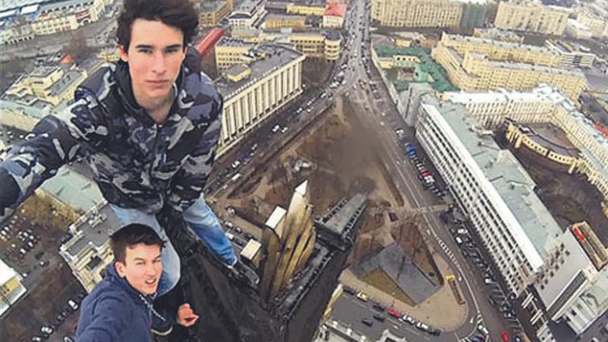 El ruso Kirill Oreshkin, pionero de los selfis de alto riesgo, se saca uno con otro joven en lo alto de un edificio.