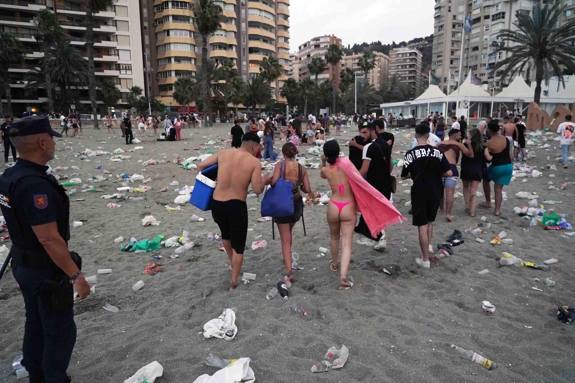 Varios operarios de la empresa de limpieza de Limasam, recogen los residuos de la playa de La Malagueta, tras la Noche de San Juan en Málaga 2025