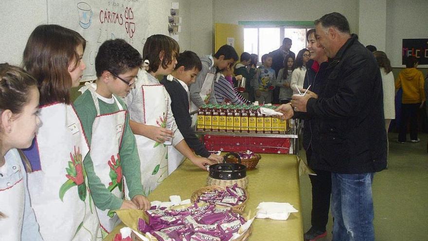 Padres recogen el chocolate y las galletas repartidas por los alumnos del colegio Hospital de la Cruz.