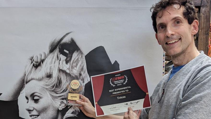 Javier Ideami, ante el cartel de Cannes con la tarjeta de su premio.