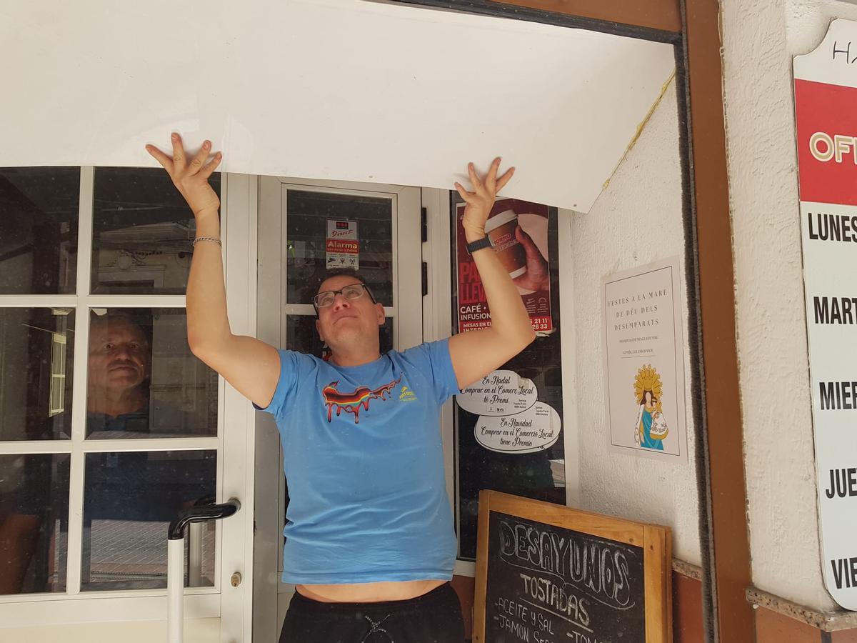 Un comerciante, al intentar bajar la persiana de forma manual.
