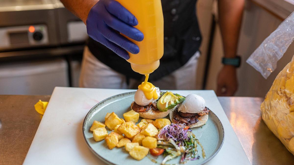 Un cocinero prepara un plato de 'brunch' de huevos benedictinos en el restaurante Petit Pot.