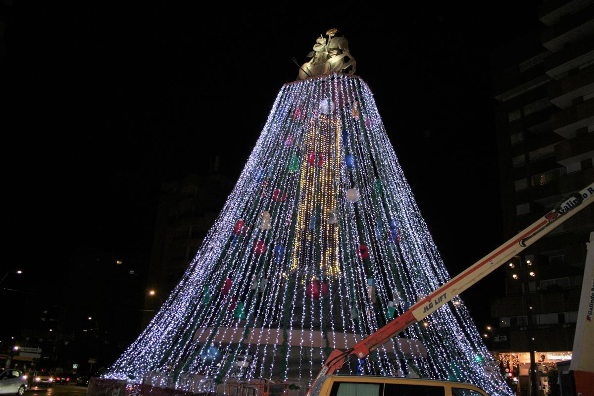 Los técnicos aplicaban a las guirnaldas que caen desde lo más alto de la escultura ‘Apoteosis’ las distintas tonalidades con que contará el árbol de Navidad.