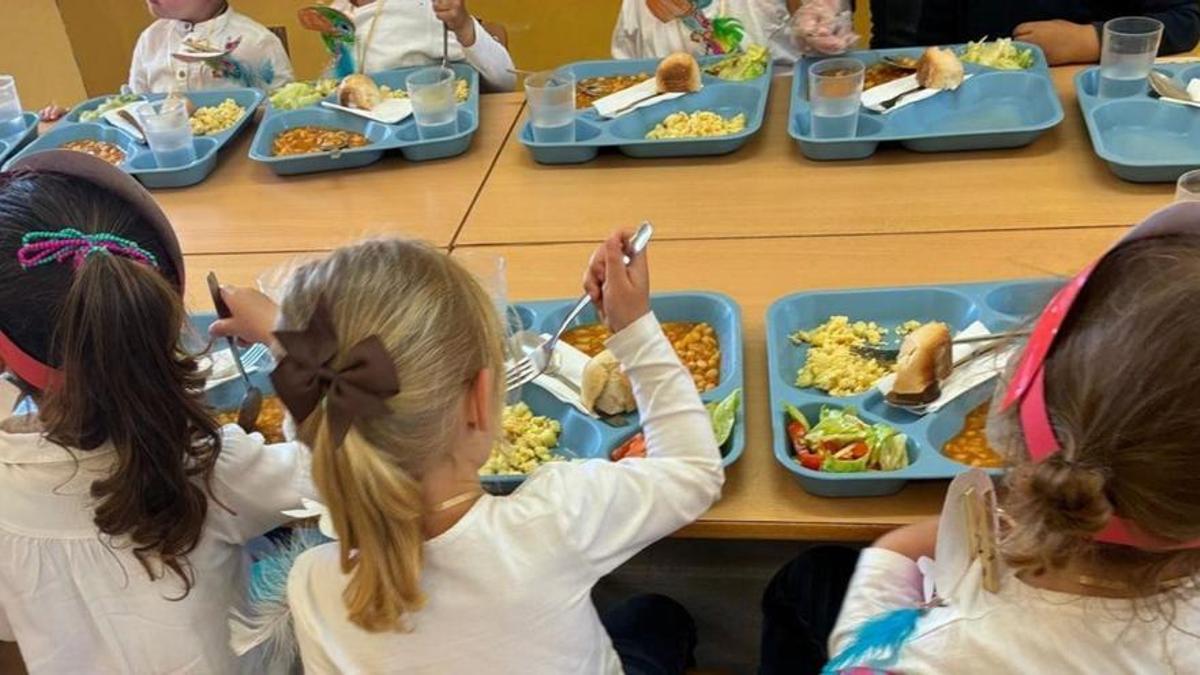Niñas almuerzan en un comedor escolar