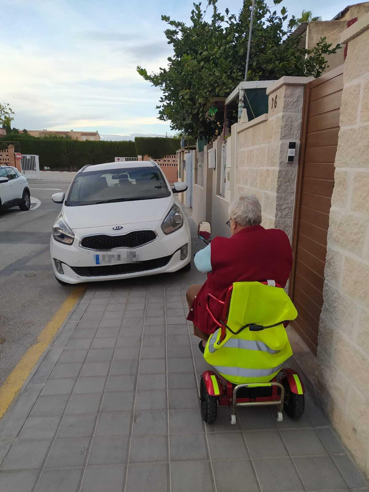 Los coches impiden el paso a una mujer con movilidad reducida en la calle Luis Vives del barrio de San Agustín, en Alicante.
