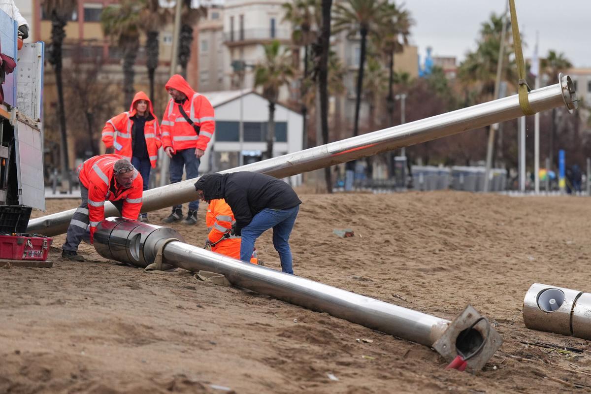 Operarios retiran las torres de megafonía de la playa de la Barceloneta durante el temporal, a 19 de enero de 2026, en Barcelona, Cataluña (España).