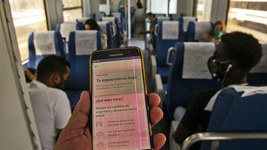 Un viajero consulta su app en el vagón de un tren.