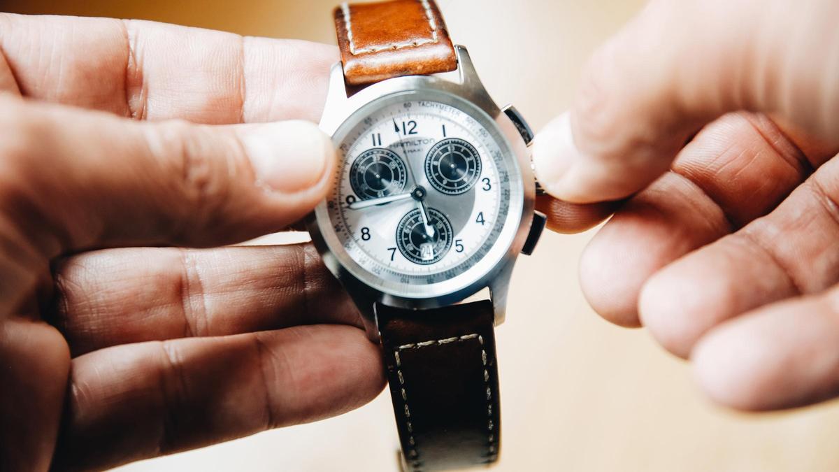 Una persona cambia la horade las manecillas reloj