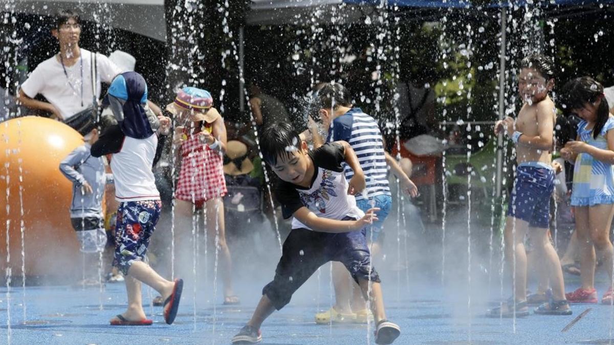 Niños jugando con una fuente en Toko, en plena ola de calor en Japón.