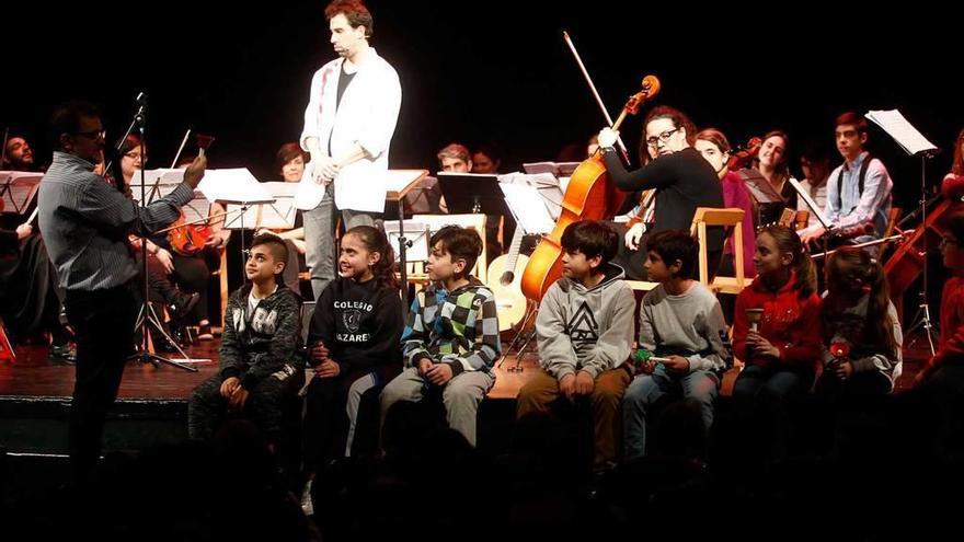 Un grupo de escolares, ayer, sobre el escenario del Filarmónica con la orquesta de Cámara de Siero.