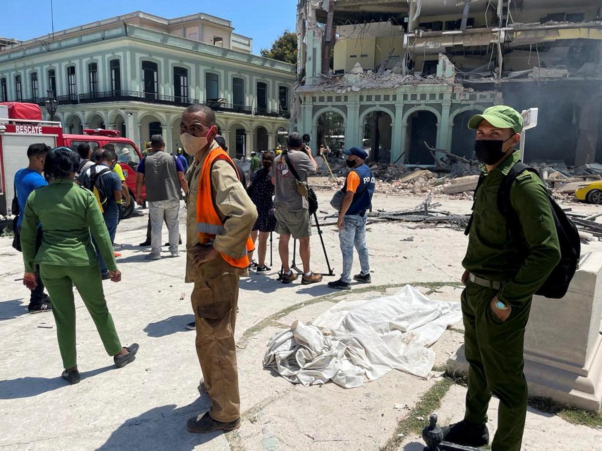 El cuerpo tapado de una víctima yace en la calle tras una explosión que destruyó el Hotel Saratoga, en La Habana