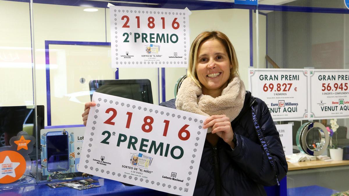 La responsable de l'administració número 14 de Pi i Margall, de Lleida, amb un cartell que indica que ha venut una sèrie del segon premi, el número 21.816